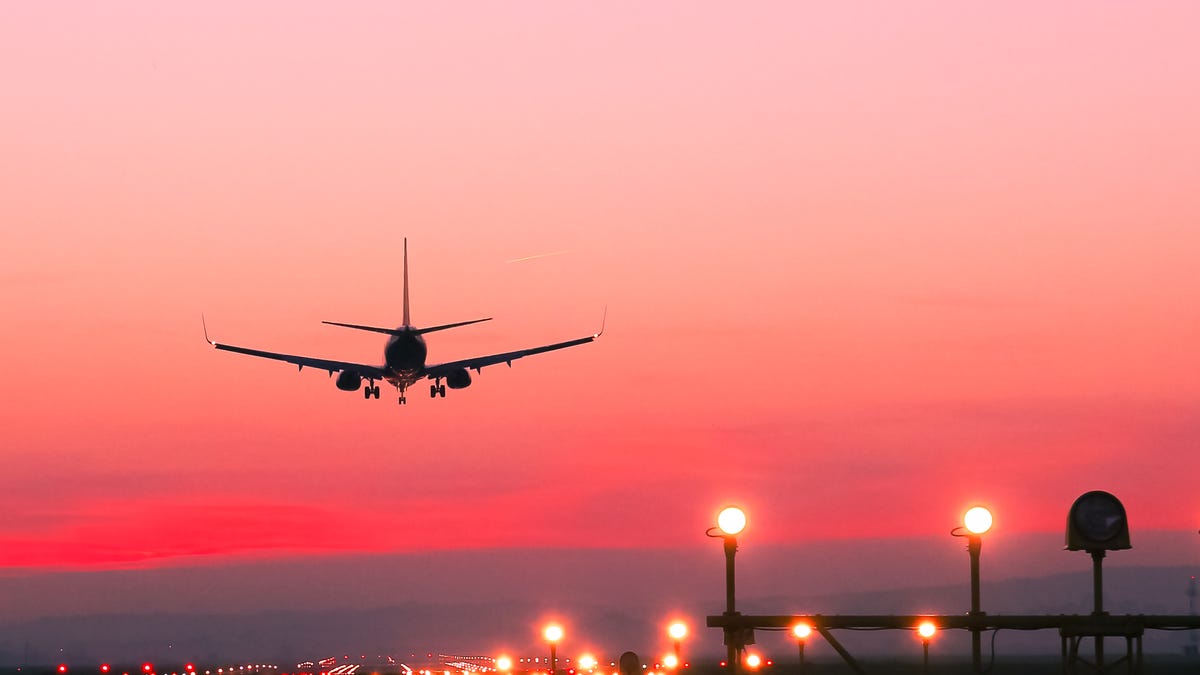A plane landing at sunset