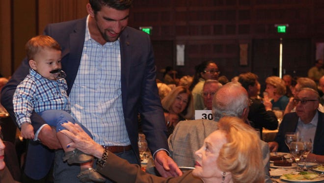 MIchael Phelps and son Boomer talk with Barbara Sinatra at the Champions Honor Luncheon in Rancho Mirage, March 3, 2017.