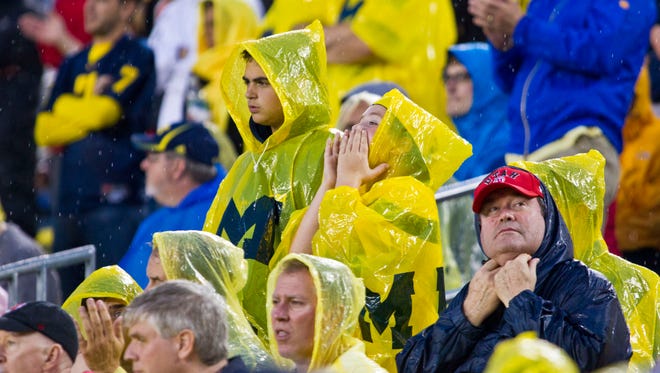 Michigan and Utah fans wear rain gear in Ann Arbor on Sept. 20, 2014.