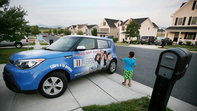 A young boy walks by a vehicle from Nexus Services Inc., which helped his family find a home in Waynesboro after they left Honduras.