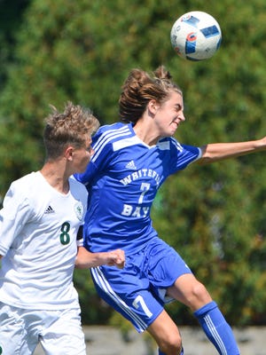 Whitefish Bay forward Matthew Comiskey heads the ball while competing with Wauwatosa West midfielder Tyler Hipke.