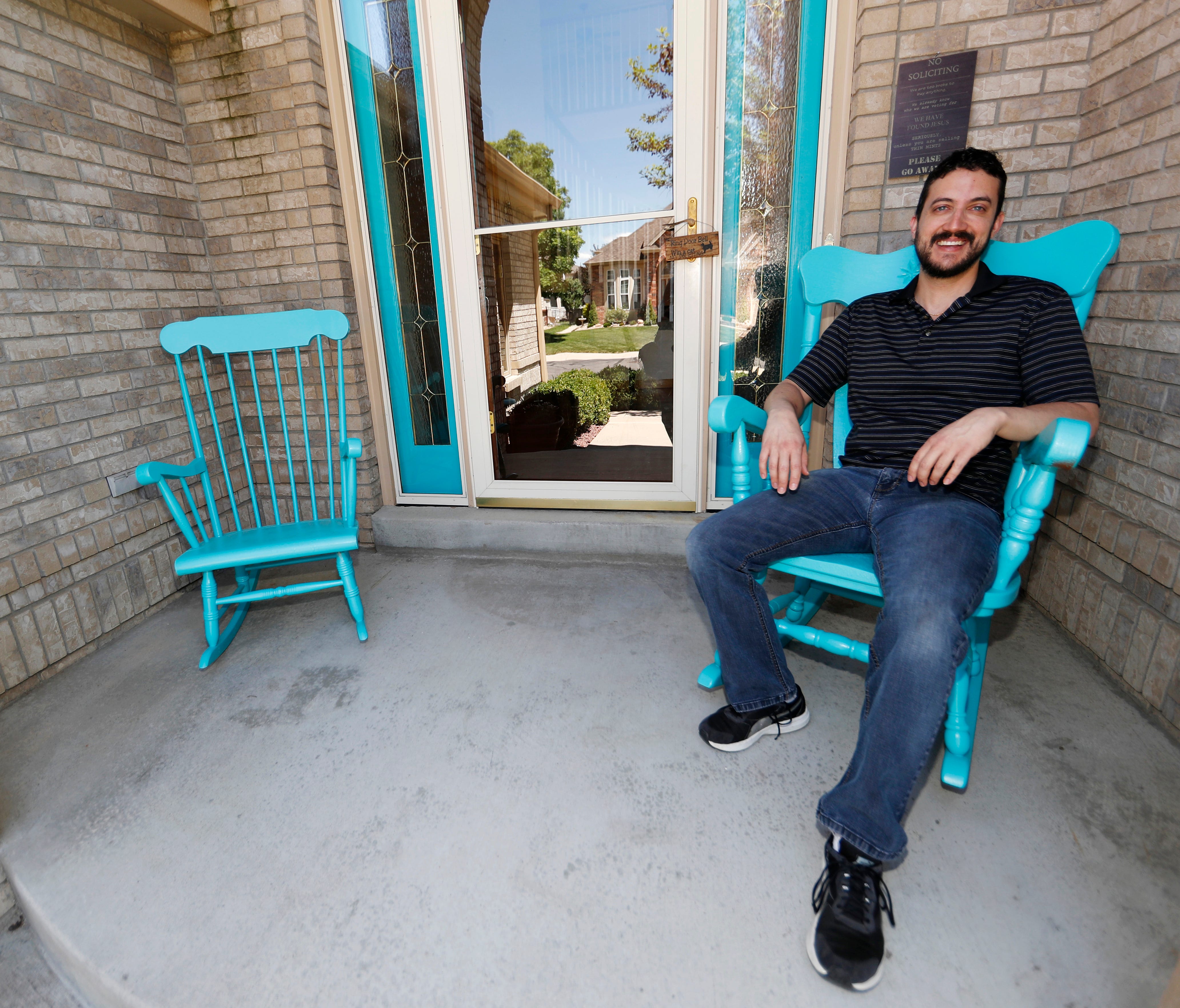 Danny Aguilar takes a seat in one of the rocking chair on the front porch of his home in Lakewood, Colo. Aguilar, like nearly half of Americans surveyed in a new poll conducted by The Associated Press-NORC Center Public Affairs Research, said they wi