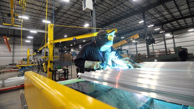 An employee works on welding a sheet of aluminum panel Friday afternoon at Linetec in Wausau.