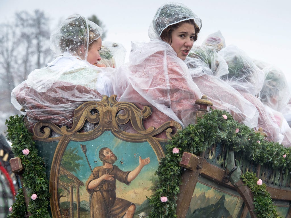 Women in traditional festive costumes ride on a traditional carriage during the \