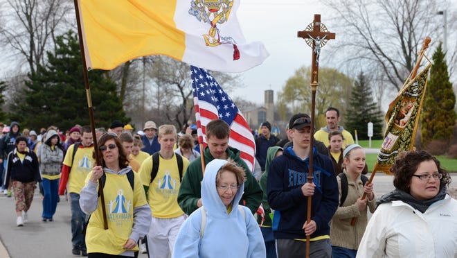 
Participants leave the National Shrine of St. Joseph at St. Norbert Abbey in De Pere at the start of the inaugural Walk to Mary in May 2013. The annual walking pilgrimage follows a 21-mile route to The Shrine of Our Lady of Good Help in Champion.
