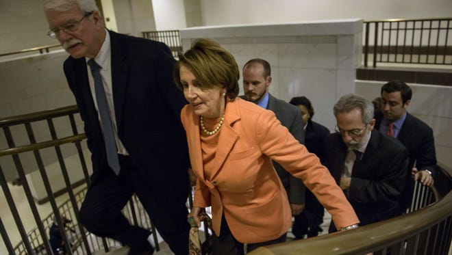 Rep. George Miller, left, and House Minority Leader Nancy Pelosi, D-Calif., leave a meeting of House Democrats on Capitol Hill on Dec. 11, 2014.