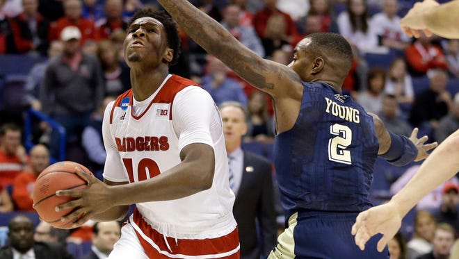 Wisconsin's Nigel Hayes, left, heads to the basket as Pittsburgh's Michael Young defends during the first half in a first-round men's college basketball game in the NCAA tournament, Friday, March 18, 2016, in St. Louis. (AP Photo/Jeff Roberson)