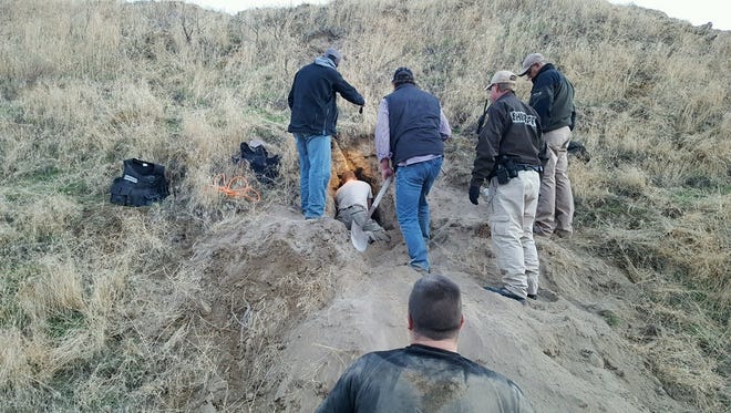 Law enforcement agents attempt to dig Gregory Morrow out of a giant badger hole Thursday.