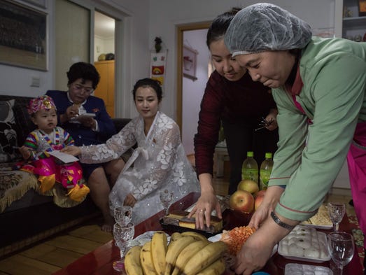 Song Song-Hui (C) sits with relatives gathered at her
