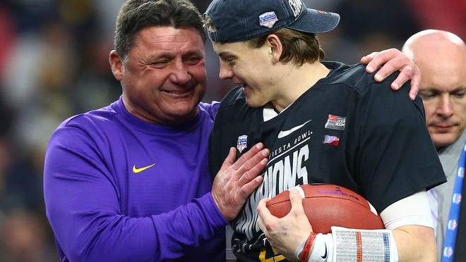 LSU head coach Ed Orgeron, left, celebrates a win against UCF with quarterback Joe Burrow, right, after a Fiesta Bowl NCAA college football game Tuesday, Jan. 1, 2019, in Glendale, Ariz. LSU defeated UCF 40-32. (AP Photo/Ross D. Franklin)