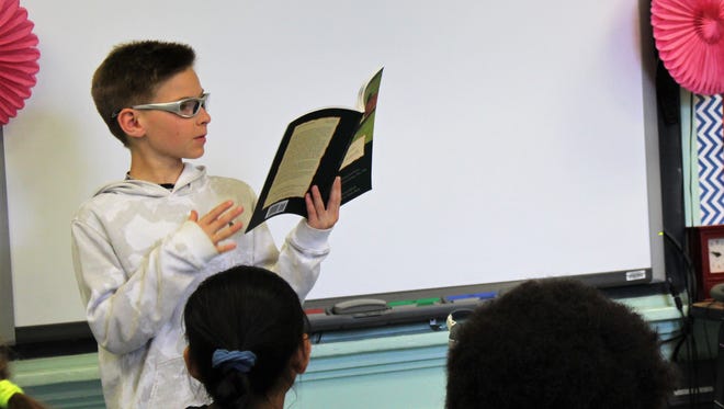 Central School 5th grader Ryan Johnson reads a poem on May 16 from I Never Saw Another Butterfly, as part of a powerful language arts unit on the Holocaust.