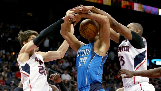 Dallas Mavericks forward Richard Jefferson attempts a shot while defended by Atlanta Hawks guard Kyle Korver and center Al Horford during the first quarter of their game.