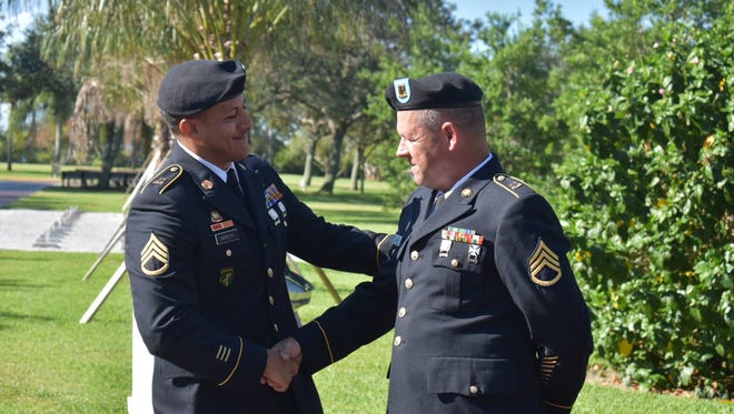 Staff Sergeant Andres Moreira congratulates retiring Staff Sergeant Jason Cranman.