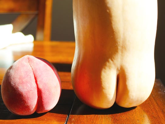 A peach and a butternut squash with rude-looking cracks