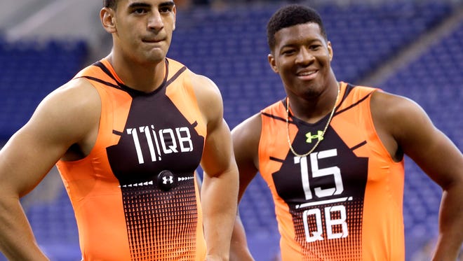 Oregon quarterback Marcus Mariota (11) and Florida State quarterback Jameis Winston (15) wait to run a drill at the NFL football scouting combine in Indianapolis, Saturday, Feb. 21, 2015.