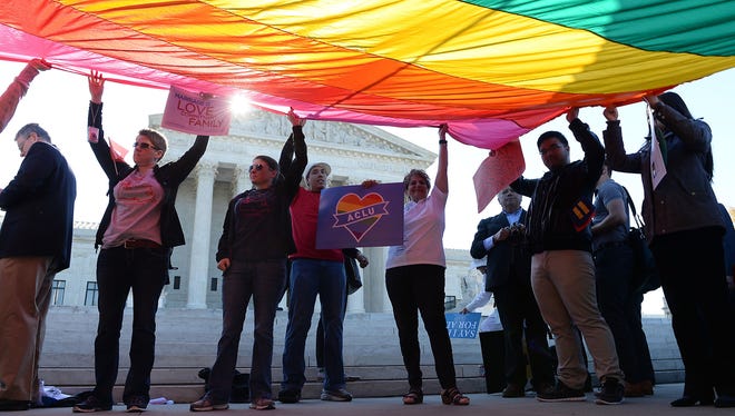 Gay Marriage Advocates Hold A Rainbow Flag In Front Of The Supreme Court As Arguments Began In A