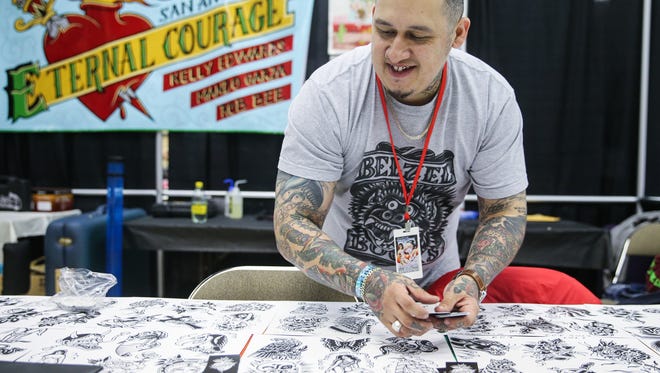 Rob Bee from San Antonio spreads his cards out on his table during the 9th annual San Angelo Tattoo Convention Friday, Feb. 23, 2018, at McNease Convention Center.