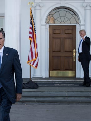 Mitt Romney walks to speak to the press as President-elect Donald Trump gives the thumbs up after their meeting at Trump International Golf Club, November 19, 2016 in Bedminster Township, New Jersey. Trump and his transition team are in the process of filling cabinet and other high level positions for the new administration. 