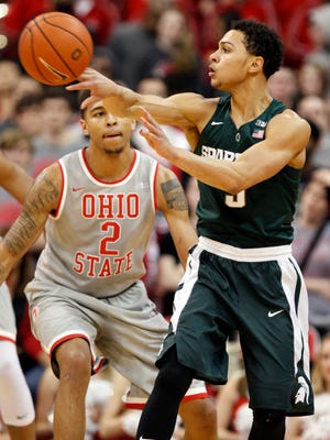 Michigan State's Bryn Forbes, right, passes the ball in front of Ohio State's Marc Loving during the second half of an NCAA college basketball game in Columbus, Ohio, Tuesday. Michigan State won 81-62.