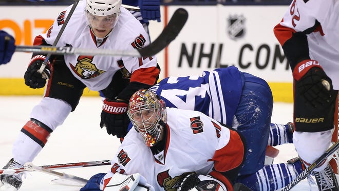 Ottawa Senators goalie Craig Anderson (41) looks up as defenseman Mark Borowiecki (74) watches as Toronto Maple Leafs center Nazem Kadri (43) lays on top of him at Air Canada Centre.