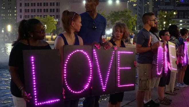 A group holds letters spelling out "Love One Another" at the vigil honoring the five slain Dallas police officers on June 11, 2016.