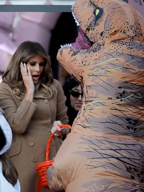 First lady Melania Trump playfully reacts to the dinosaur
