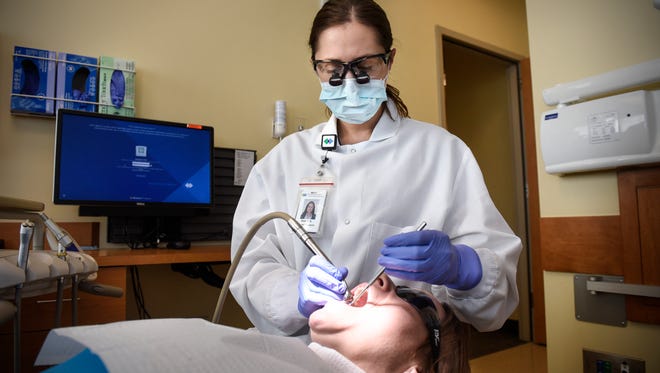 A dental therapist works in a clinic in Sartell, Minn.