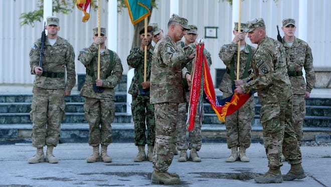 U.S. generals fold their unit flag during an end-of-mission ceremony at Bagram Air Base, Afghanistan, on Nov. 4.