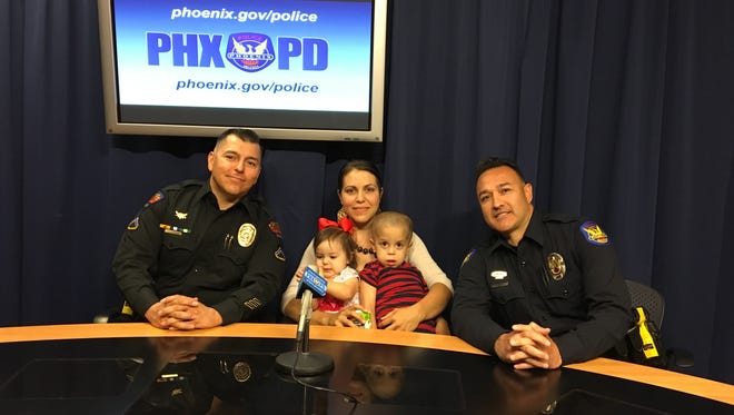 Laura Castaneda (center), Avondale mom of seven, with Officer Hugo Lopez (right) of the Phoenix Police Department and Detective Edward Corona (left) of the Avondale Police Department, and her two youngest children.
