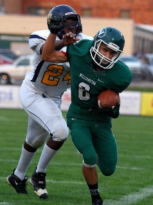 Williamston's Michael Walter, right, is pushed out of bounds by Lansing Eastern's Kyangelo Robinson after catching a pass Friday, Aug. 28, 2015, in Williamston.