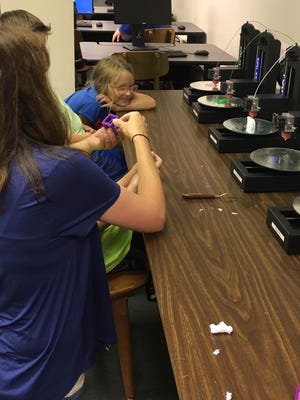 A Pine Belt student works with USM's Anna Wan using the 3D printers in the new Makerspace.