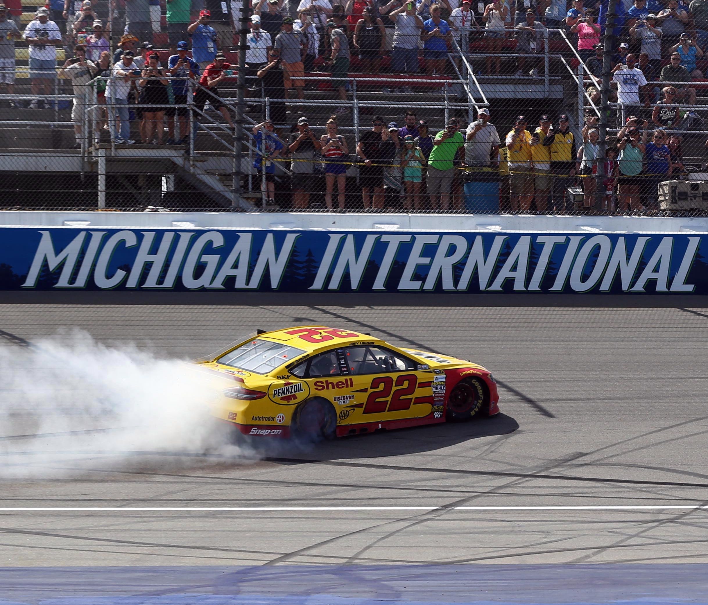 Joey Logano (22) does a burnout after winning the 2016 FireKeepers Casino 400 at Michigan International Speedway.