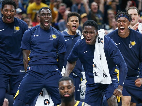 Players on the Indiana Pacers bench react to a call