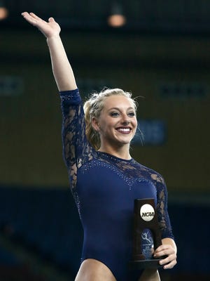 UCLA's Samantha Peszek waves to fans after being introduced as the balance beam champion following the NCAA women's gymnastics championships Sunday, April 19, 2015, in Fort Worth, Texas.