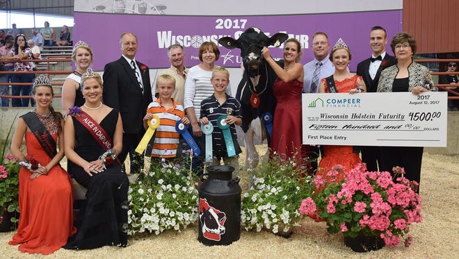 Wisconsin Holstein Association Futurity Champion Ryan-Vu Chelios Mocha is joined by (back row from left) WI Holstein Association Princess Attendant Kelsey Cramer, WI Secretary of Ag Ben Brancel, Cameron Ryan, Mark Ryan, Mary Ryan, Dylan Ryan, Amy Ryan, Chad Ryan, WI Holstein Princess Courtney Moser, WHA Futurity judge Jerome Meyer, and Compeer Financial Representative Dawn Haag. Also on hand was (front row from left)
WI State Fairest of the Fair Rebecca Starkenburg and Alice in Dairyland- Crystal Siemers-Peterman.