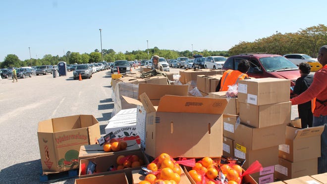 Volunteers distribute food from Second Harvest Food Bank of Southeast North Carolina and Action Pathways to Cumberland County residents. A new coronavirus relief bill includes $12 million for food banks in North Carolina.