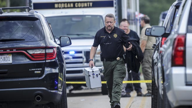 A Morgan County, Ala. investigator works at the scene, Friday, June 5, 2020, in Valhermoso Springs, Ala., where numerous people were found fatally shot. Deputies responding to a call about a shooting in Alabama found seven people dead inside a home that had been set afire early Friday, authorities said.