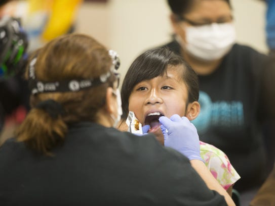 Young students get their teeth checked during the annual
