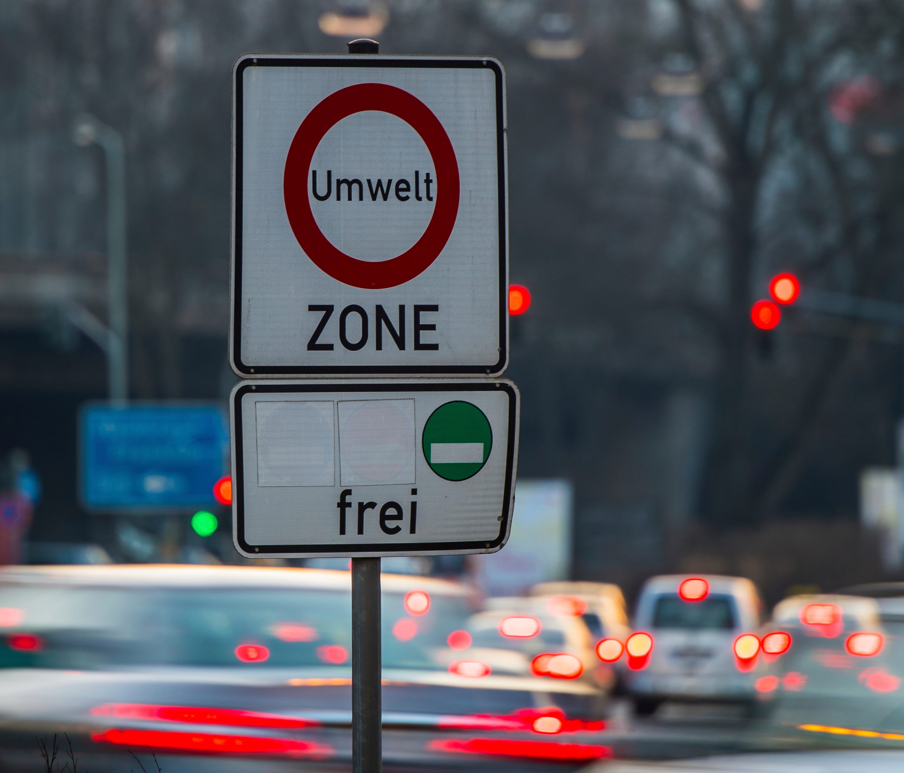 Cars pass by a sign reading 'environment zone' and allowing entrance just for cars with low emissions recognizable on a green sticker in Frankfurt, Germany, Thursday, Feb. 22, 2018.