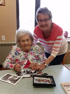 Louise Tostenrud with her daughter, Kay Weber, review photos from her past.