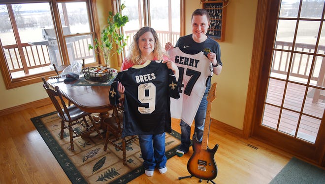 Laura and her son Damon Scott show celebrity donated items they have Friday, March 30, at their home in Dell Rapids. The items will be auctioned off at a fundraiser next week to raise money for the MS Society. Laura was sent a signed guitar from Luke Bryan and The Beach Boys along with signed NFL jerseys.