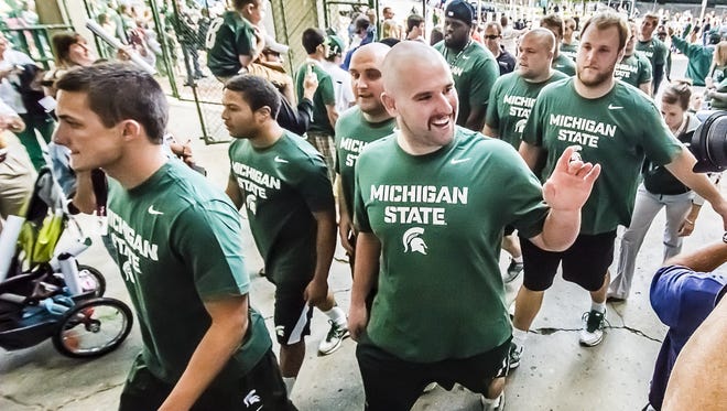 Members of the MSU offensive unit greet their fans as arrive at the "Meet the Spartans" event in 2013 at Spartan Stadium.