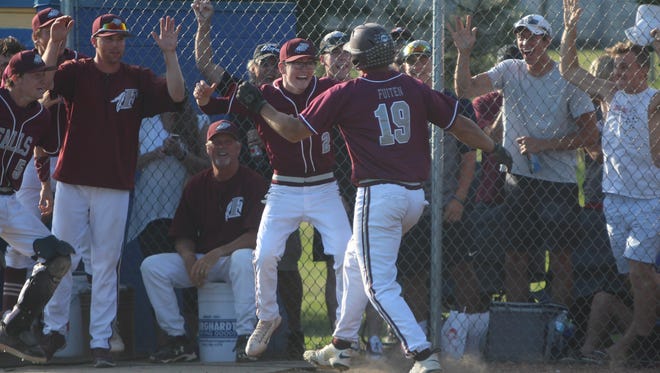 Menomonee Falls players and fans are all smiles as they greet Dayne Fuiten (19) after he hit a go-ahead double and scored a run in Monday's sectional final against Germantown.