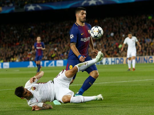 Roma's Diego Perotti, tries to stop Barcelona's Luis Suarez, right, during a Champions League quarter-final, first leg soccer match between FC Barcelona and Roma at the Camp Nou stadium in Barcelona, Spain, Wednesday, April 4, 2018.(AP Photo/ Manu Fernandez)