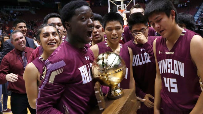 Winslow's Yoann Djassa (L) reacts after holding the 3A Boys State Championship trophy for the first time after Winslow beat Blue Ridge at Gila River Arena on February 26, 2018 in Glendale, Ariz. 