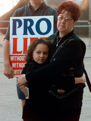 Norma McCorvey, right, known as Jane Roe in the landmark U.S. Supreme Court ruling that legalized abortion nationwide, stands with her friend Meredith Champion, 9, at an Operation Rescue rally in downtown Dallas. Norma McCorvey, the "Jane Roe" at the center of the 1973 U.S. Supreme Court decision that legalized abortion, has died. She was 69. Journalist Joshua Prager, who is working on a book about McCorvey, says she died Saturday, Feb. 18, 2017, morning at an assisted living centre in Katy, Texas. Although McCorvey was the plaintiff in Roe v. Wade, she later became an anti-abortion activist. (AP Photo/Ron Heflin, File)