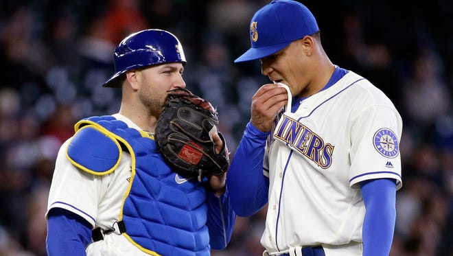 Seattle Mariners catcher Chris Iannetta, left, and starting pitcher Taijuan Walker talk after Walker gave up two home runs to the Minnesota Twins in the fourth inning of a baseball game, Sunday, May 29, 2016, in Seattle. (AP Photo/Elaine Thompson)