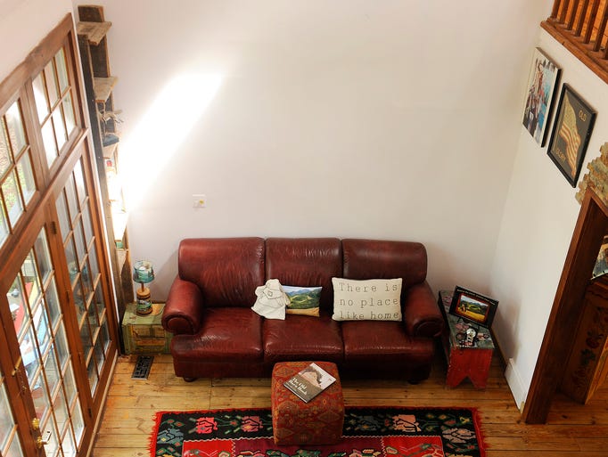 A leather sofa anchors the two-story foyer. Of all