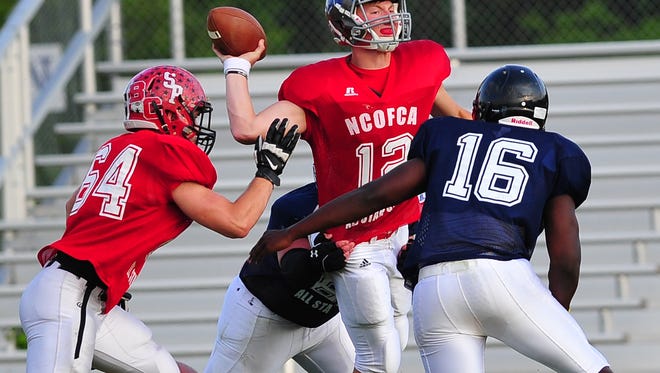 North quarterback Grant Loy of Buckeye Central attempts a pass under pressure in Saturday night's 28-19 loss to the South in the NCO All-Star Football Classic. The Bowling Green-bound Loy left the game in the second quarter after getting banged up on a sack, dealing a severe blow to the North attack.