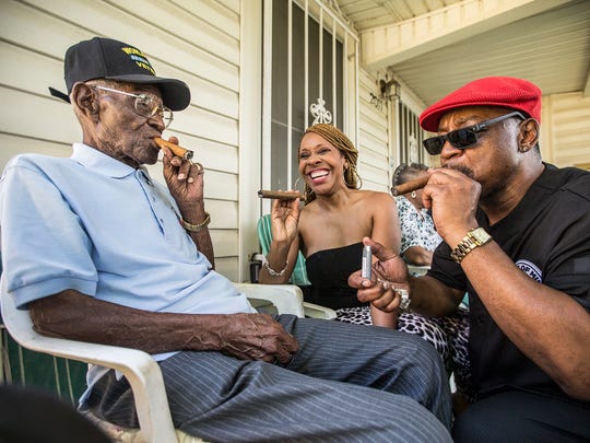   Richard Overton, left, smokes a cigar with a few neighbors 